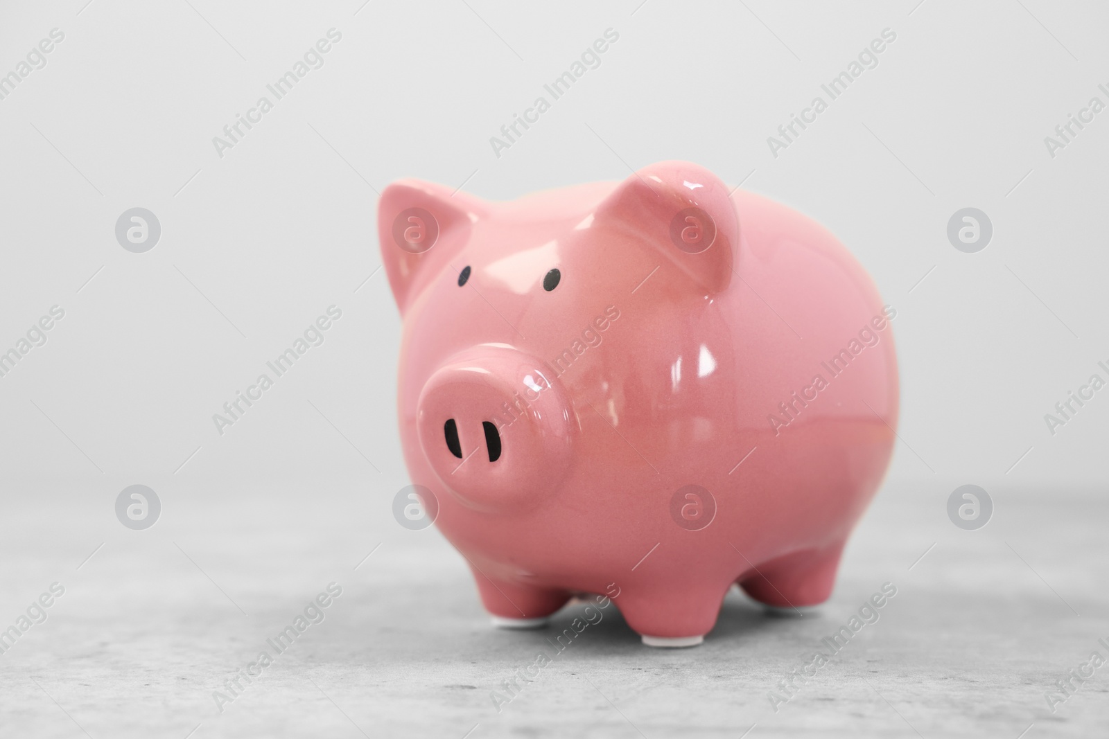 Photo of Pink ceramic piggy bank on grey table