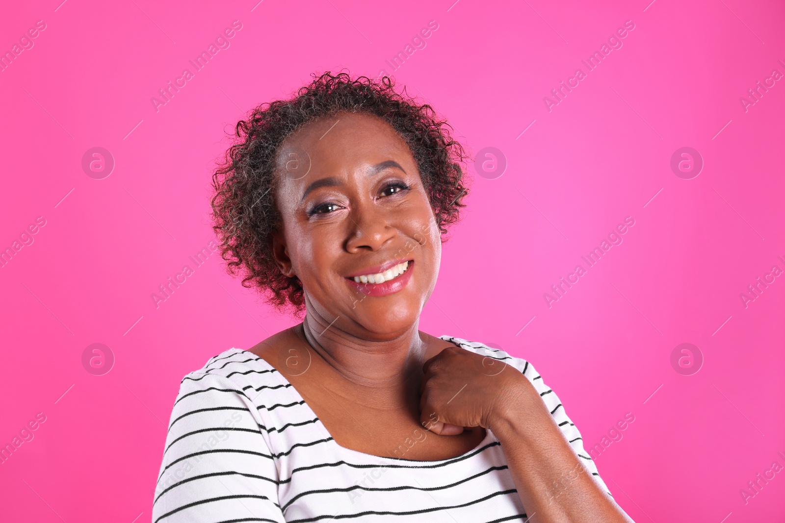 Photo of Portrait of happy African-American woman on pink background