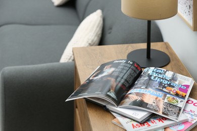 Open sports magazine and lamp on cabinet in living room