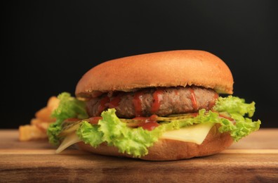 Tasty burger with patty, lettuce and cheese on wooden table, closeup