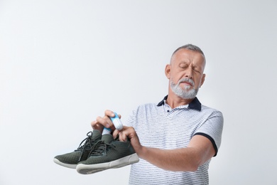 Photo of Man putting capsule shoe freshener in footwear on white background. Space for text