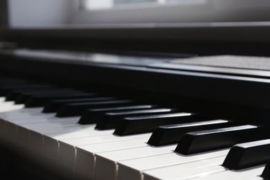 Modern piano with black and white keys indoors, closeup