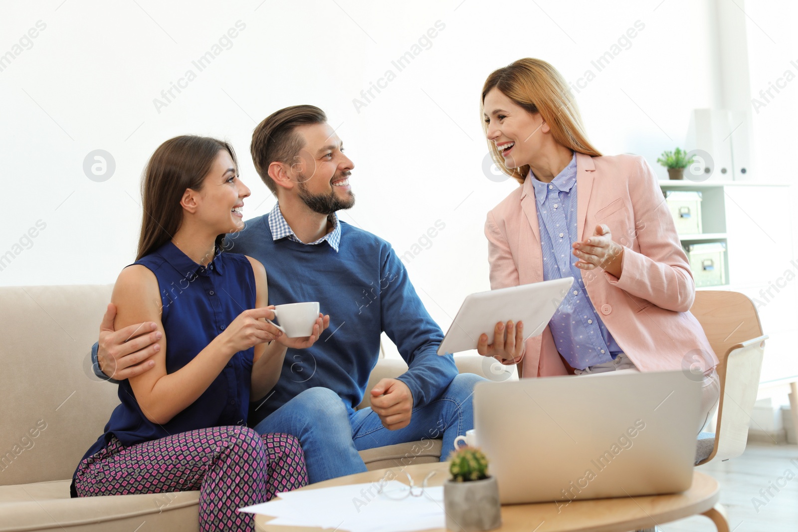 Photo of Female real estate agent working with couple in office