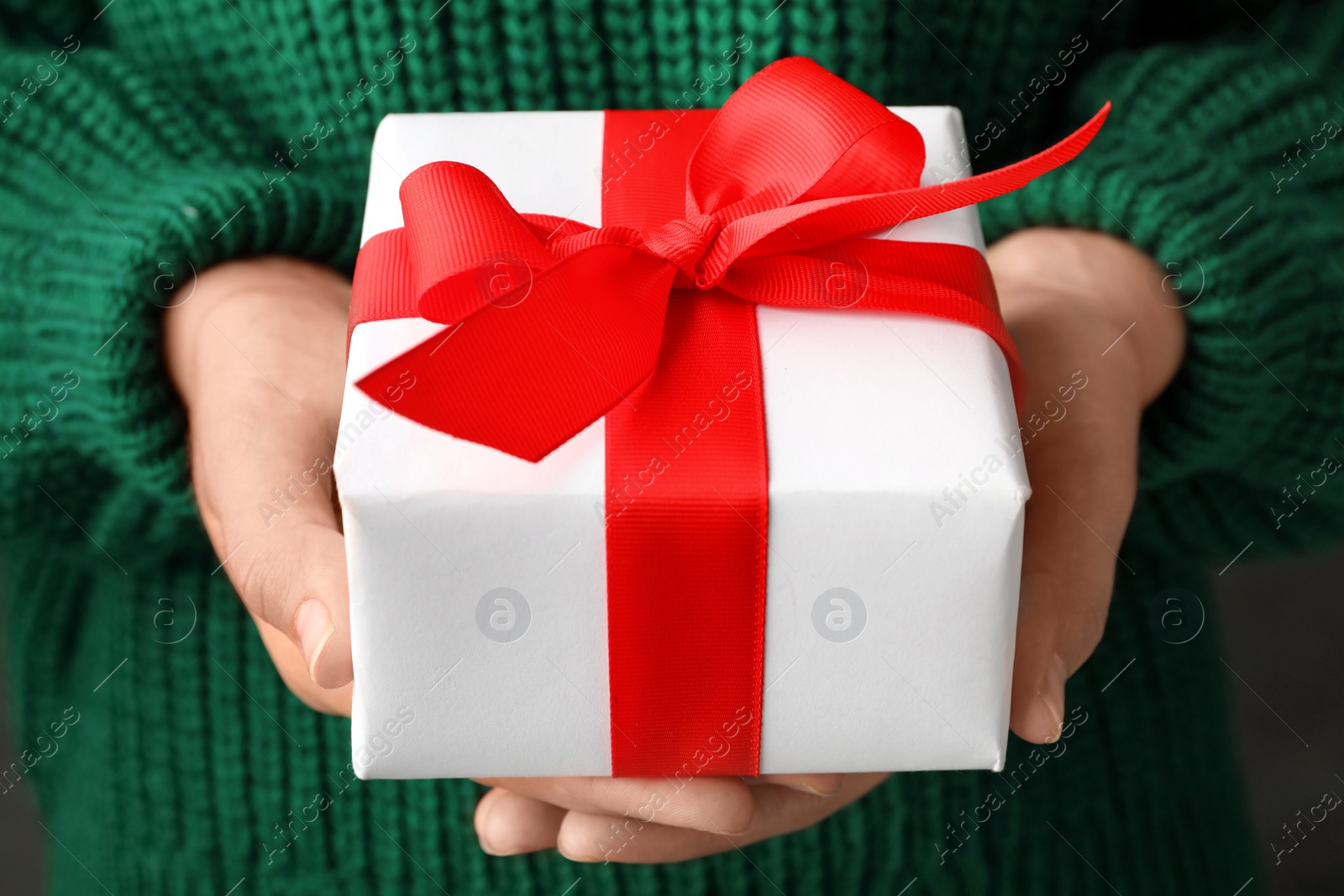 Photo of Woman holding beautiful Christmas gift with bow, closeup