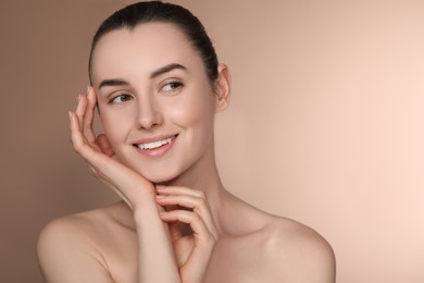 Portrait of beautiful young woman on light brown background. Space for text