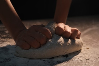 Photo of Making bread. Woman kneading dough at table, closeup