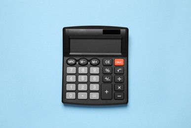 Calculator on light blue background, top view. Office stationery