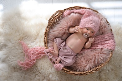 Photo of Adorable newborn baby with pacifier in wicker basket, top view