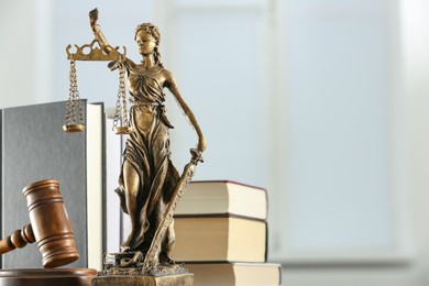 Photo of Figure of Lady Justice, gavel and books on white background, space for text. Symbol of fair treatment under law