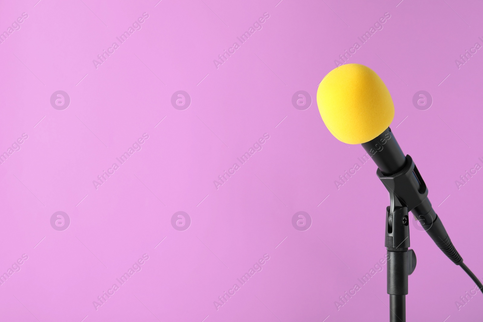 Photo of Modern microphone on color background. Space for text