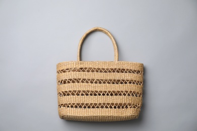 Stylish straw bag on grey background, top view. Summer accessory