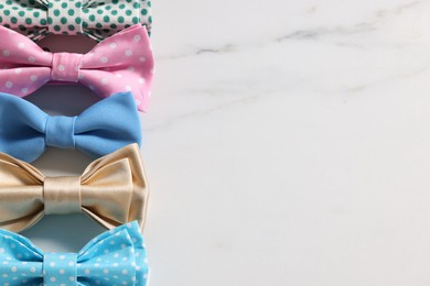 Photo of Stylish color bow ties on white background, flat lay. Space for text