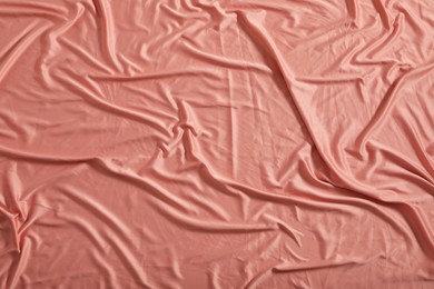 Crumpled coral fabric as background, closeup view