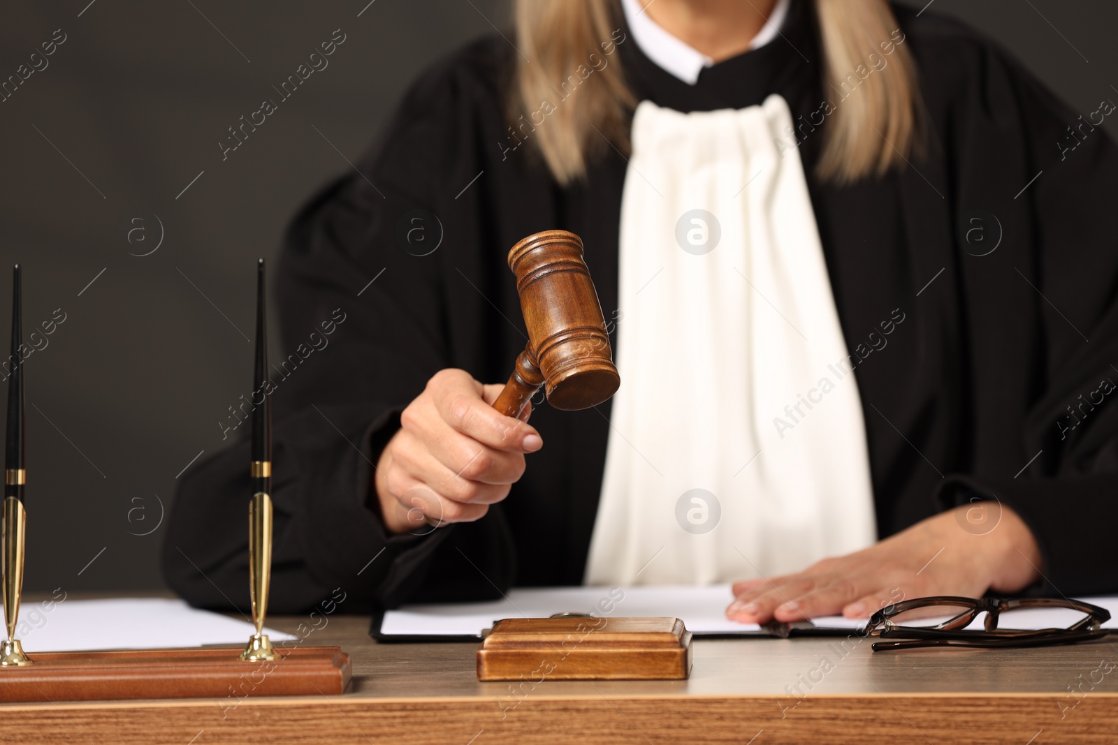 Photo of Judge striking mallet at wooden table indoors, closeup