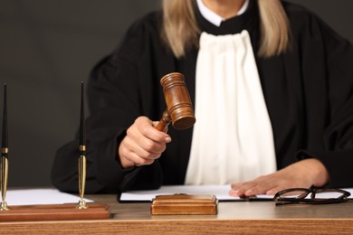 Photo of Judge striking mallet at wooden table indoors, closeup