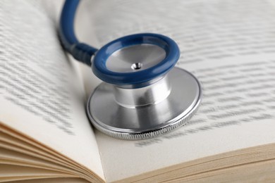 Photo of Open student textbook with and stethoscope, closeup. Medical education