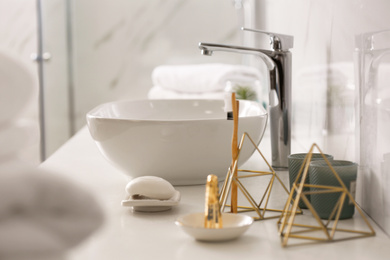 Photo of Toiletries and vessel sink on light countertop in modern bathroom