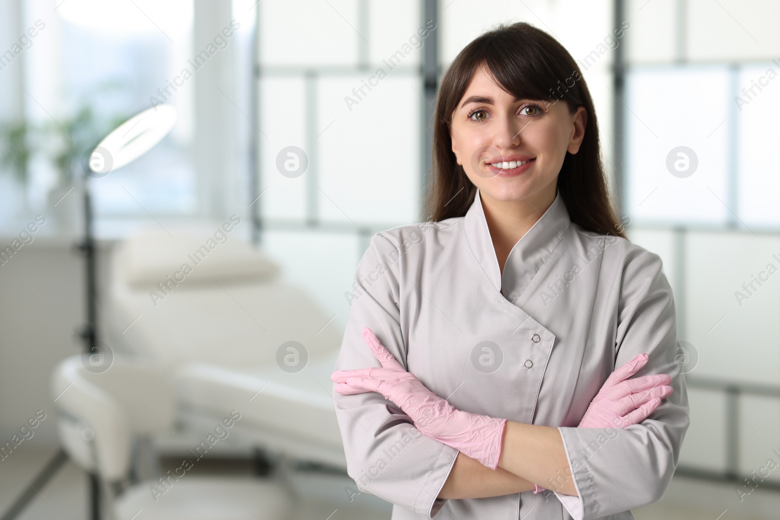 Photo of Cosmetologist in medical uniform in clinic, space for text