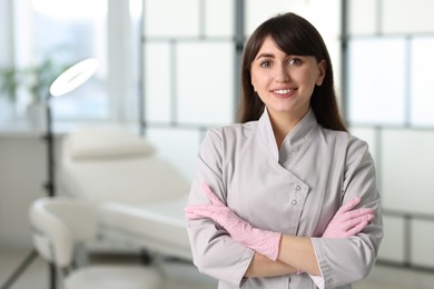 Photo of Cosmetologist in medical uniform in clinic, space for text