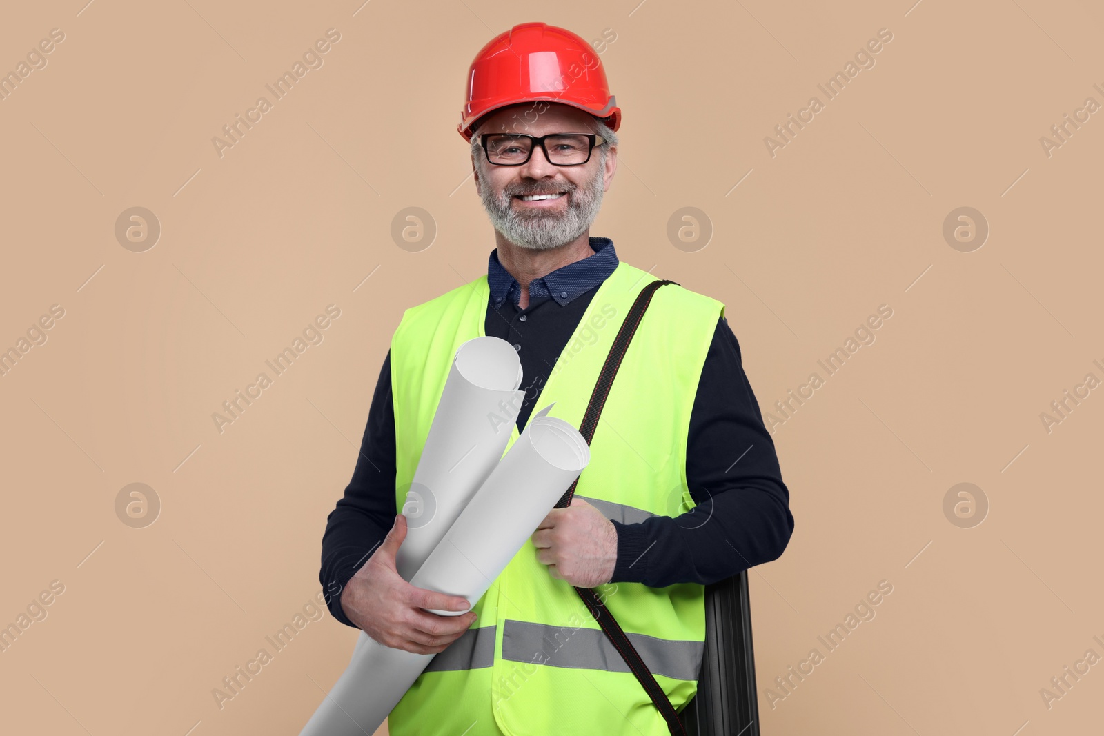 Photo of Architect in hard hat holding drafts on beige background