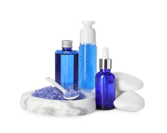 Photo of Spa composition. Bottles of cosmetic products, stones and sea salt isolated on white