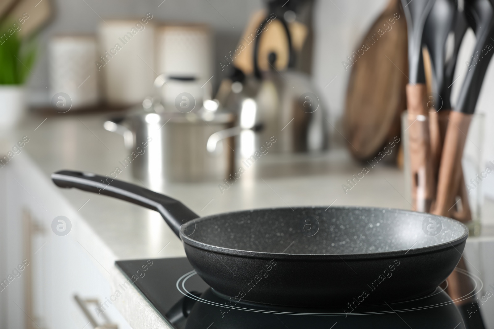 Photo of Frying pan and cooking utensils in kitchen, space for text