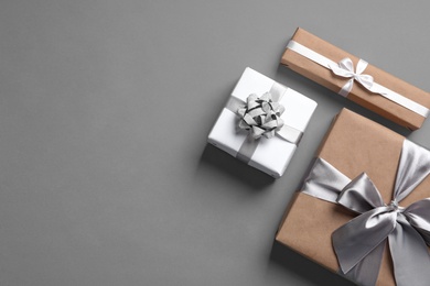 Beautifully wrapped gift boxes on grey background, top view