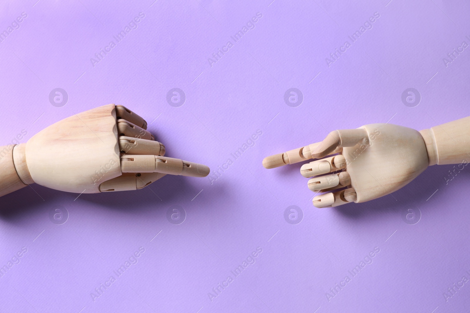 Photo of Wooden mannequin hands on lilac background, flat lay