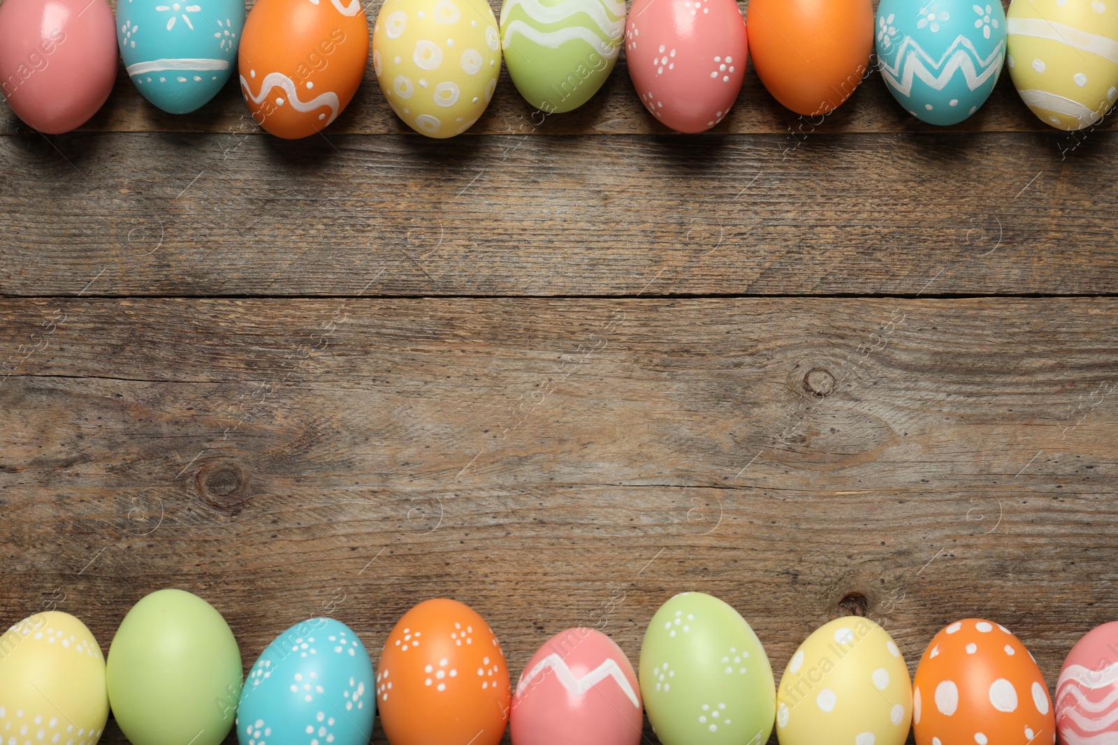 Photo of Flat lay composition of painted Easter eggs on wooden background, space for text