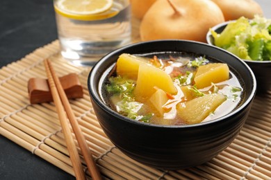 Photo of Bowl of tasty turnip soup served on table, closeup