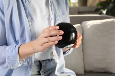 Photo of Woman holding magic eight ball indoors, closeup. Space for text