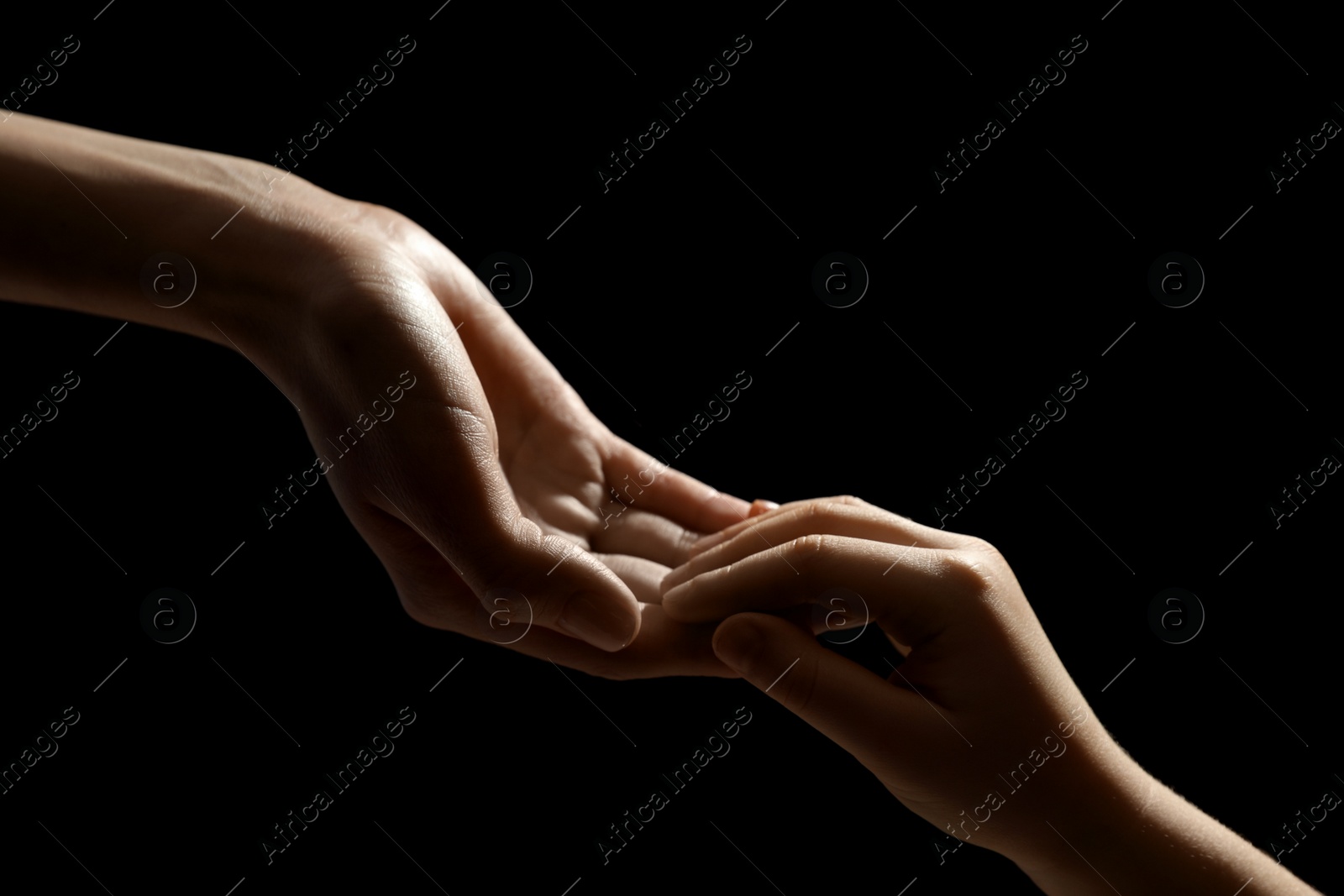 Photo of Woman with child on black background, closeup of hands