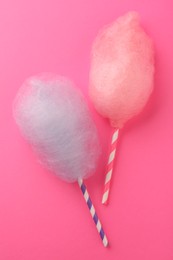 Photo of Sweet color cotton candies on pink background, flat lay