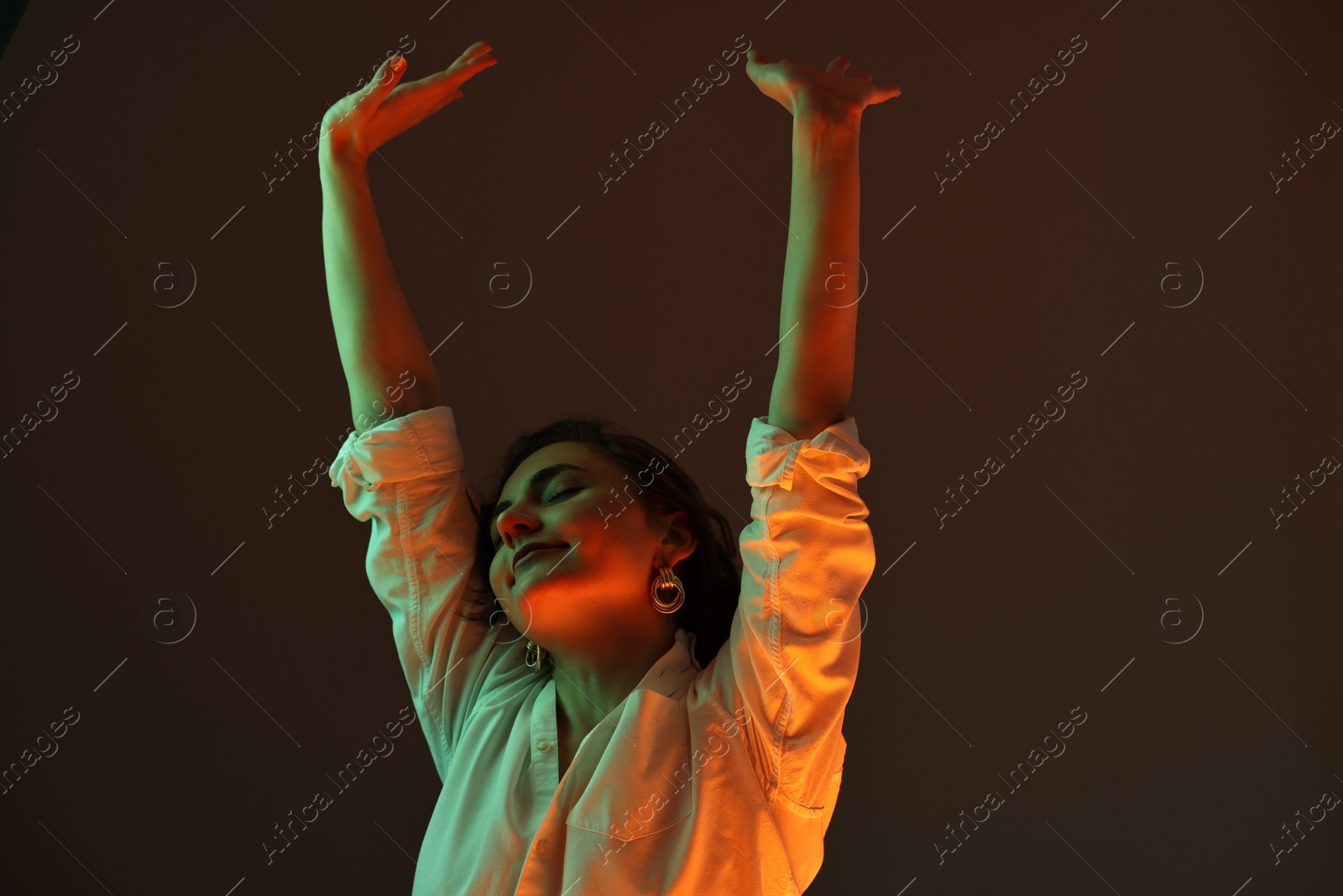 Photo of Portrait of beautiful young woman on color background with neon lights