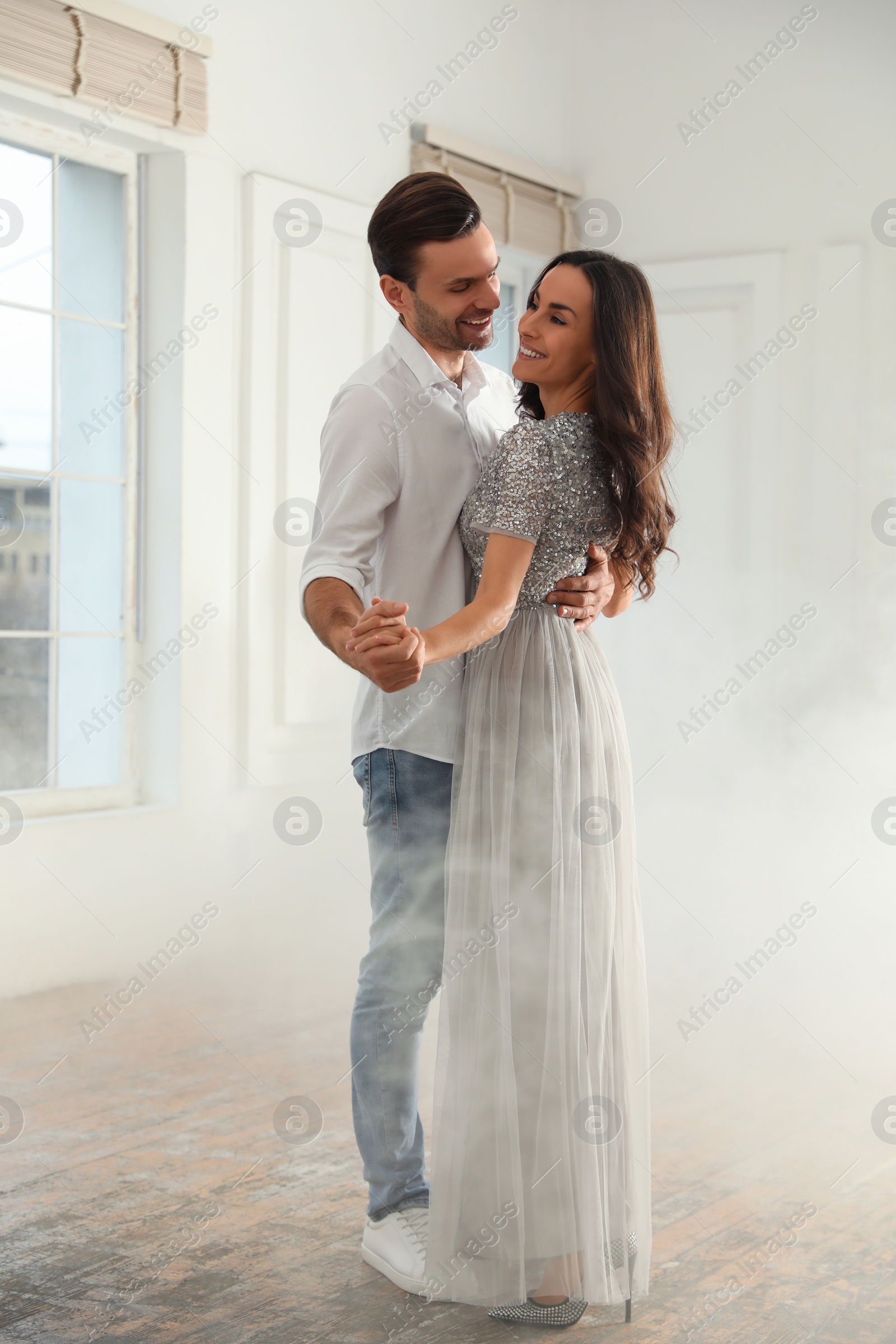 Photo of Lovely young couple dancing together in ballroom