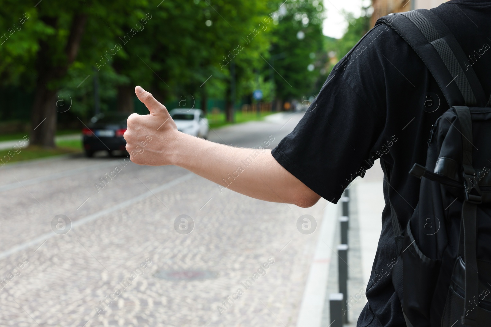 Photo of Man catching car on road, closeup. Hitchhiking trip