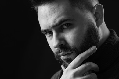 Photo of Portrait of handsome bearded man on dark background, space for text. Black and white effect