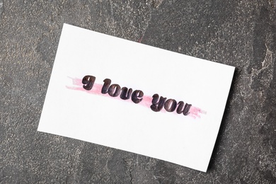 Card with text I Love You on grey stone background, top view