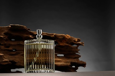 Photo of Luxury men`s perfume in bottle on grey table, space for text