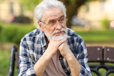 Photo of Portrait of happy grandpa with glasses on bench in park