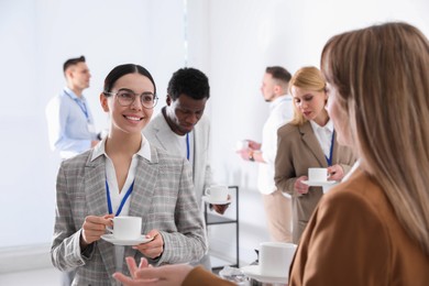 Group of people chatting during coffee break indoors