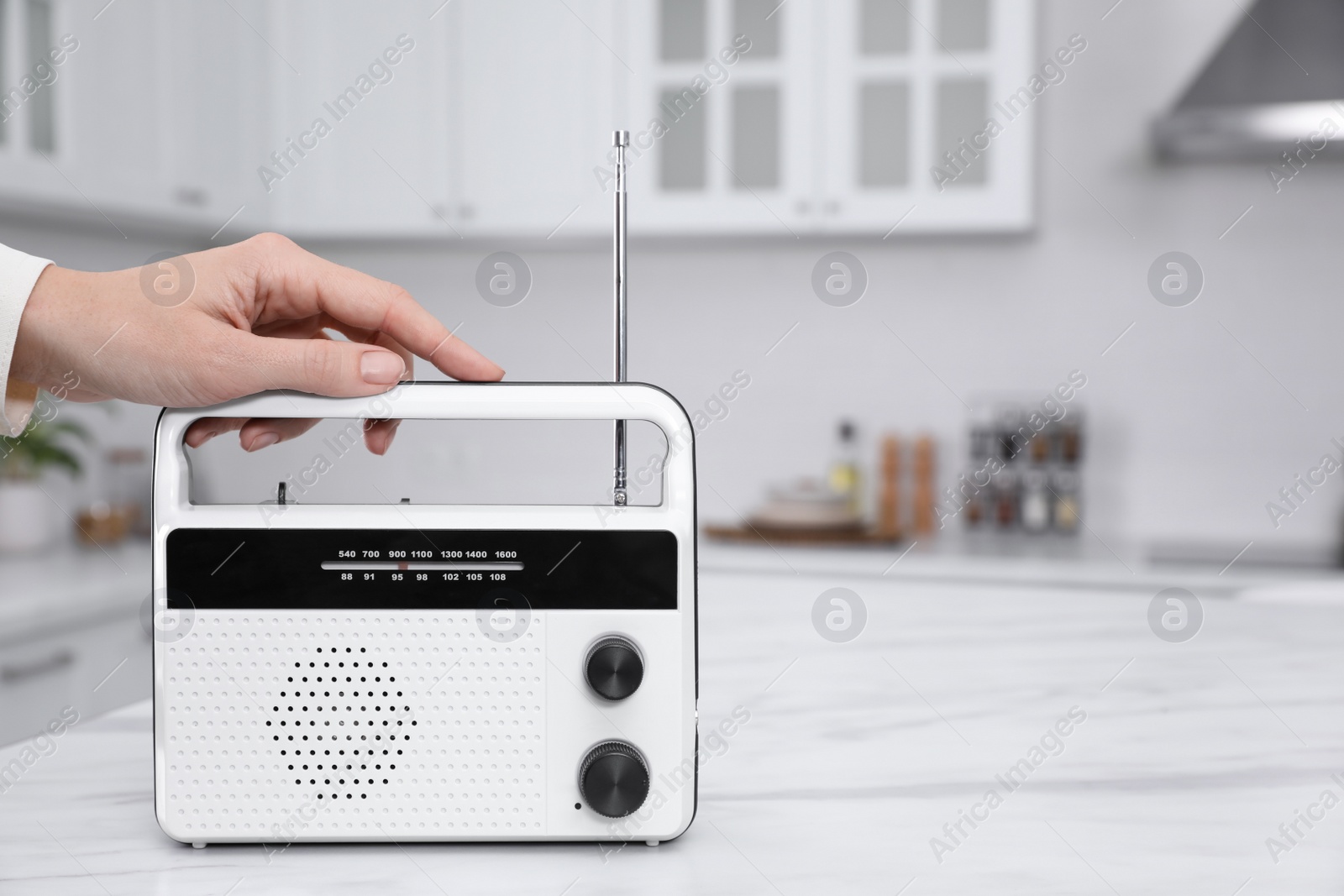 Photo of Woman with stylish white radio in kitchen, closeup. Space for text
