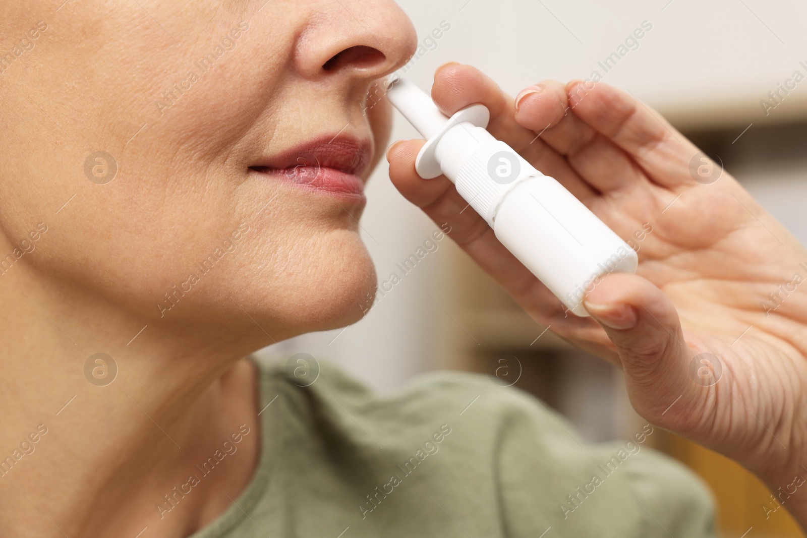 Photo of Medical drops. Woman using nasal spray indoors, closeup