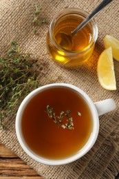 Aromatic herbal tea with thyme, honey and lemons on wooden table, top view