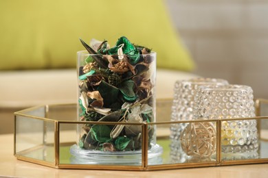 Photo of Glass jar with aromatic potpourri of dried flowers and different decor element on wooden table indoors