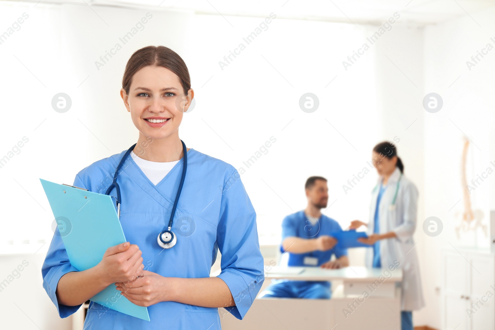 Photo of Portrait of young doctor with clipboard in hospital, space for text. Medical service