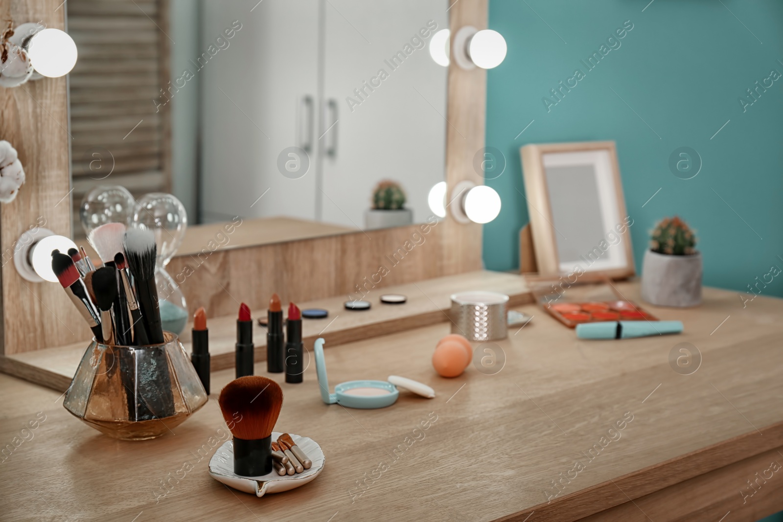 Photo of Decorative cosmetics and tools on dressing table near mirror in makeup room