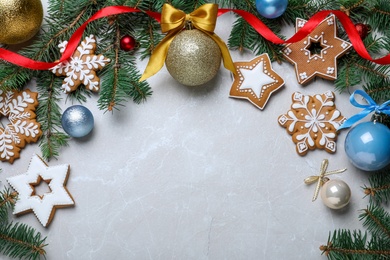 Photo of Decorated Christmas cookies, fir tree branches and festive decor on light marble table, flat lay. Space for text