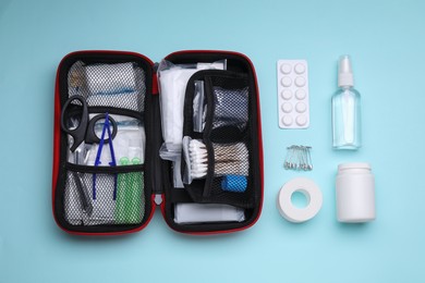Photo of Flat lay composition with first aid kit on light blue background