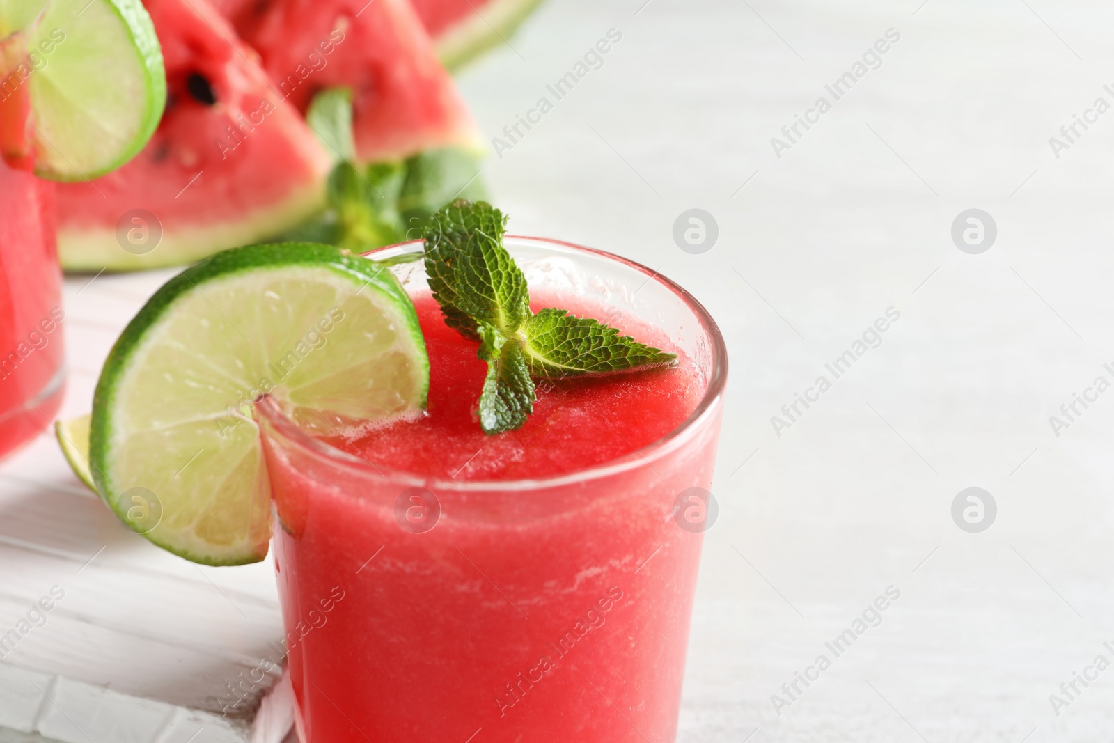 Photo of Tasty summer watermelon drink with lime and mint on table, closeup